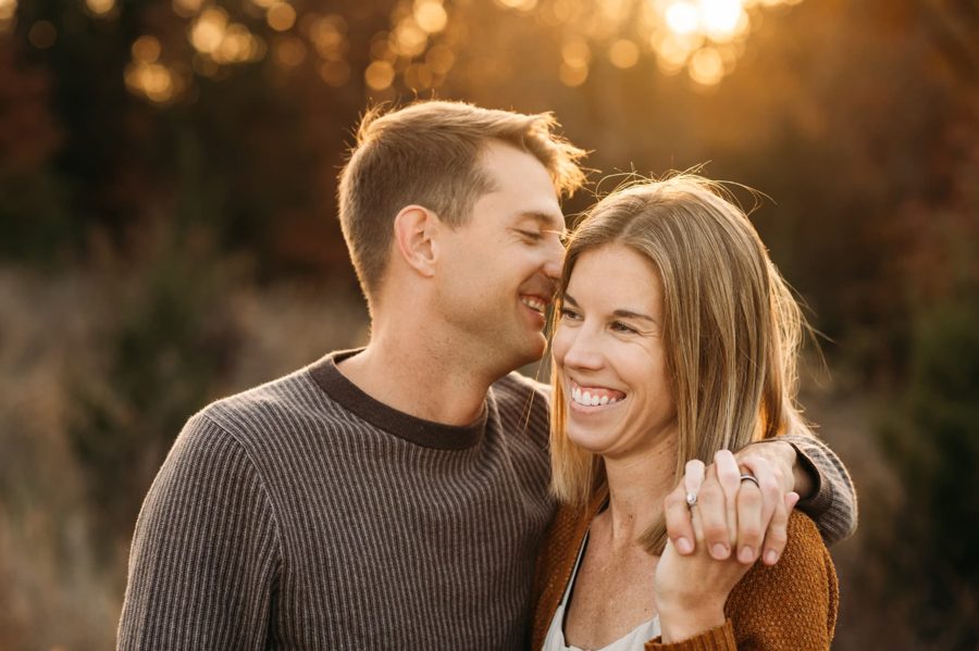 Husband and wife laughing close together at golden hour — family photography in the Kansas City area