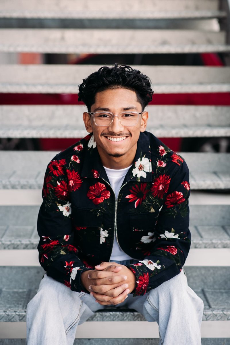 Senior guy in a floral jacket sitting on stadium steps