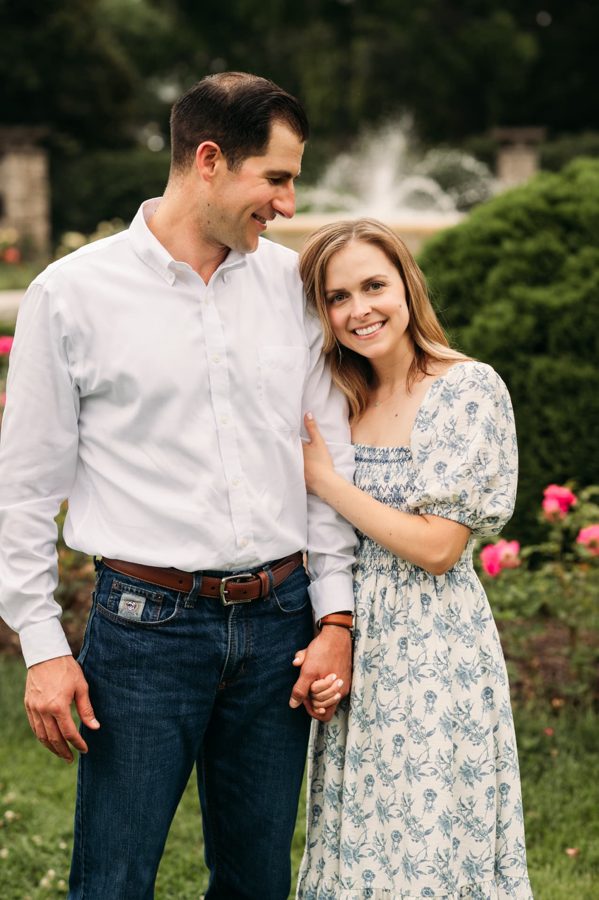 Parents holding hands in front of the rose garden fountain — family photography in the Kansas City area