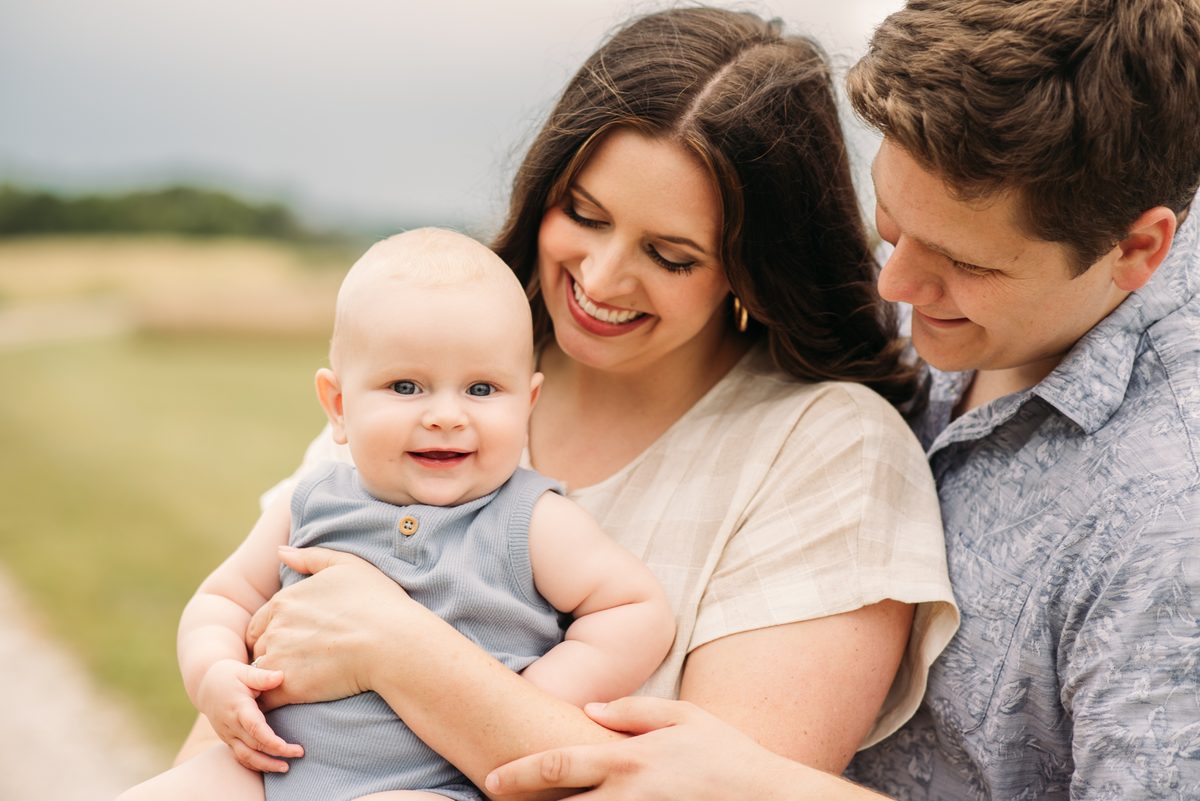 Family walking together through a sunlit field — family photography in the Kansas City area