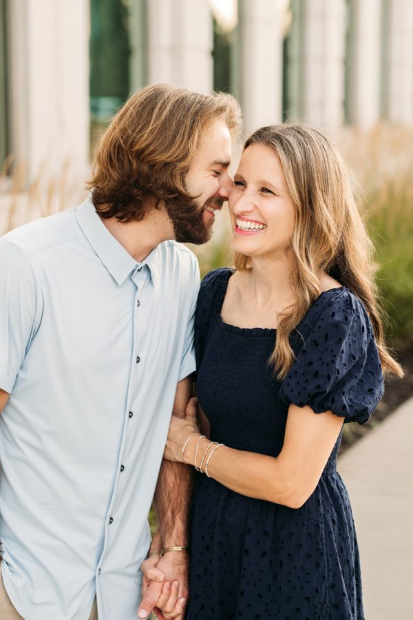 Couple laughing nose to nose on a summer evening downtown — family photography in the Kansas City area