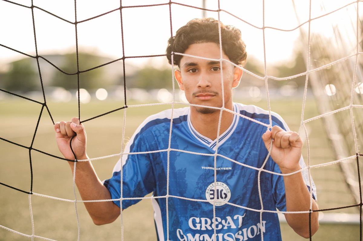 Senior soccer player framed by the goal net at golden hour — seniors photography in the Kansas City area