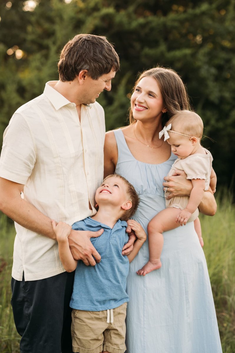 Little boy looking up at his parents while mom holds his baby sister — family photography in the Kansas City area