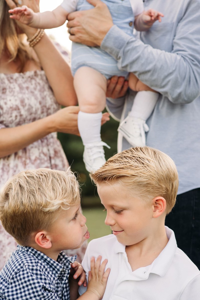 Two brothers grinning at each other during a family session — family photography in the Kansas City area