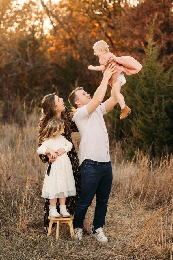 Dad tossing his toddler in the air during a fall family session — family photography in the Kansas City area