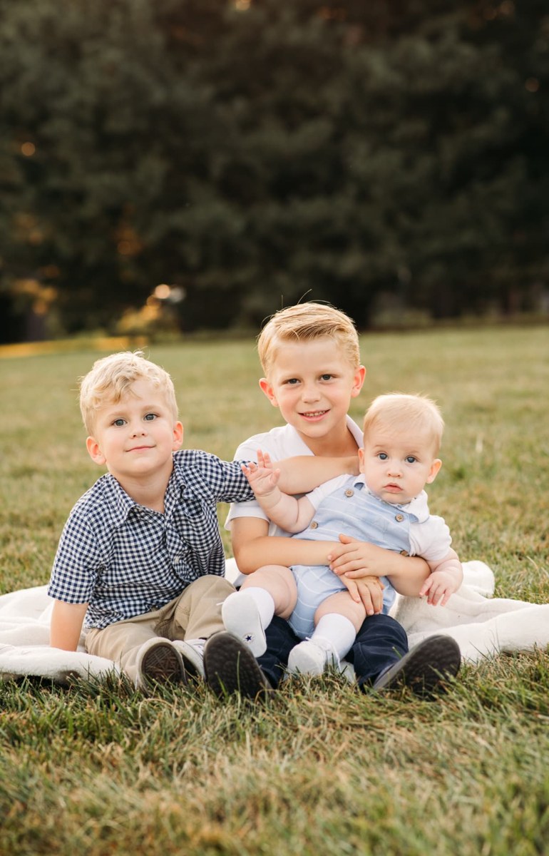 Big brother holding the baby while his brother leans in on a blanket — family photography in the Kansas City area