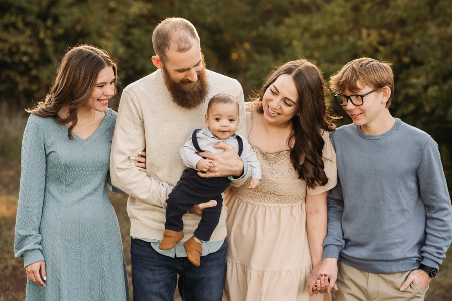Family of five walking together in an autumn field at sunset — family photography in the Kansas City area