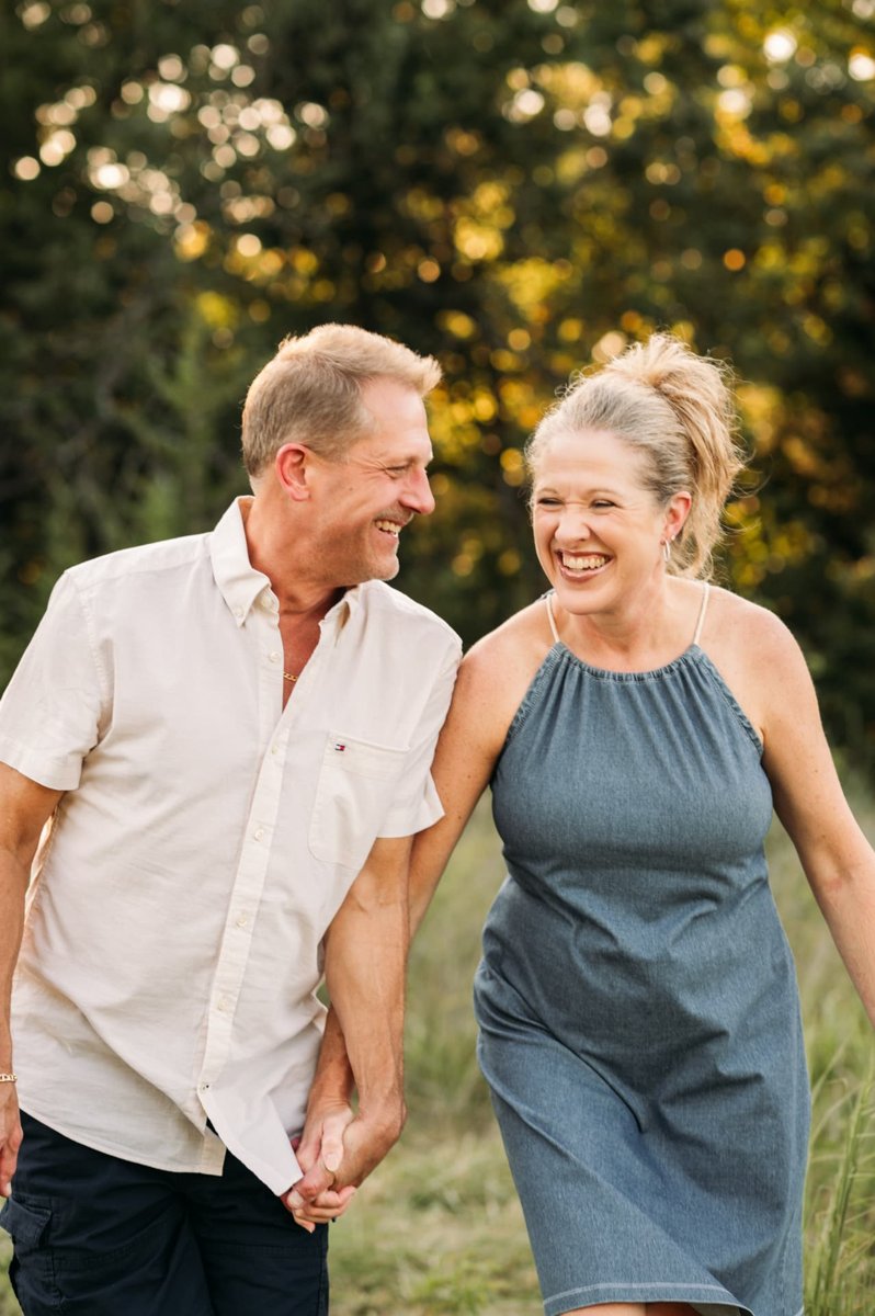 Grandparents laughing together as they walk hand in hand at golden hour — family photography in the Kansas City area