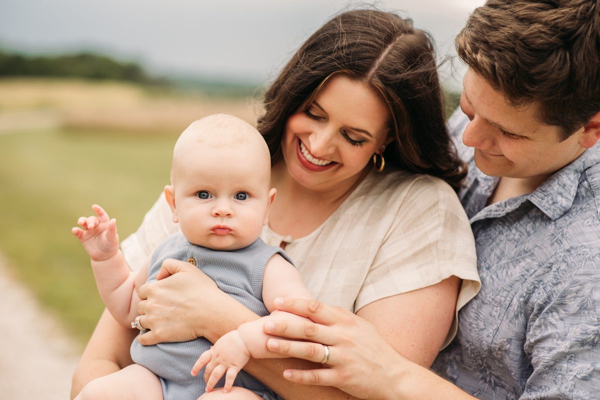Parents with their children in tall summer grass at sunset — family photography in the Kansas City area