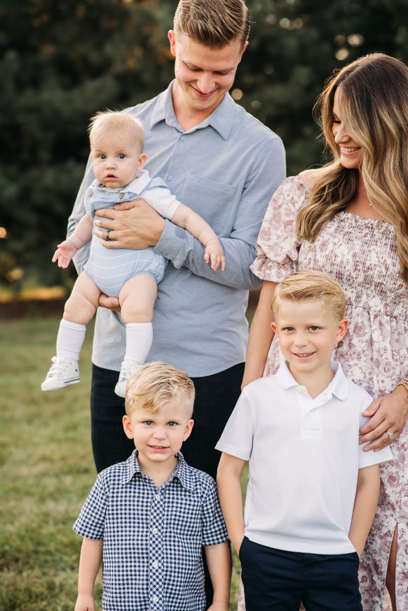 Family of five standing close together in golden evening light — family photography in the Kansas City area