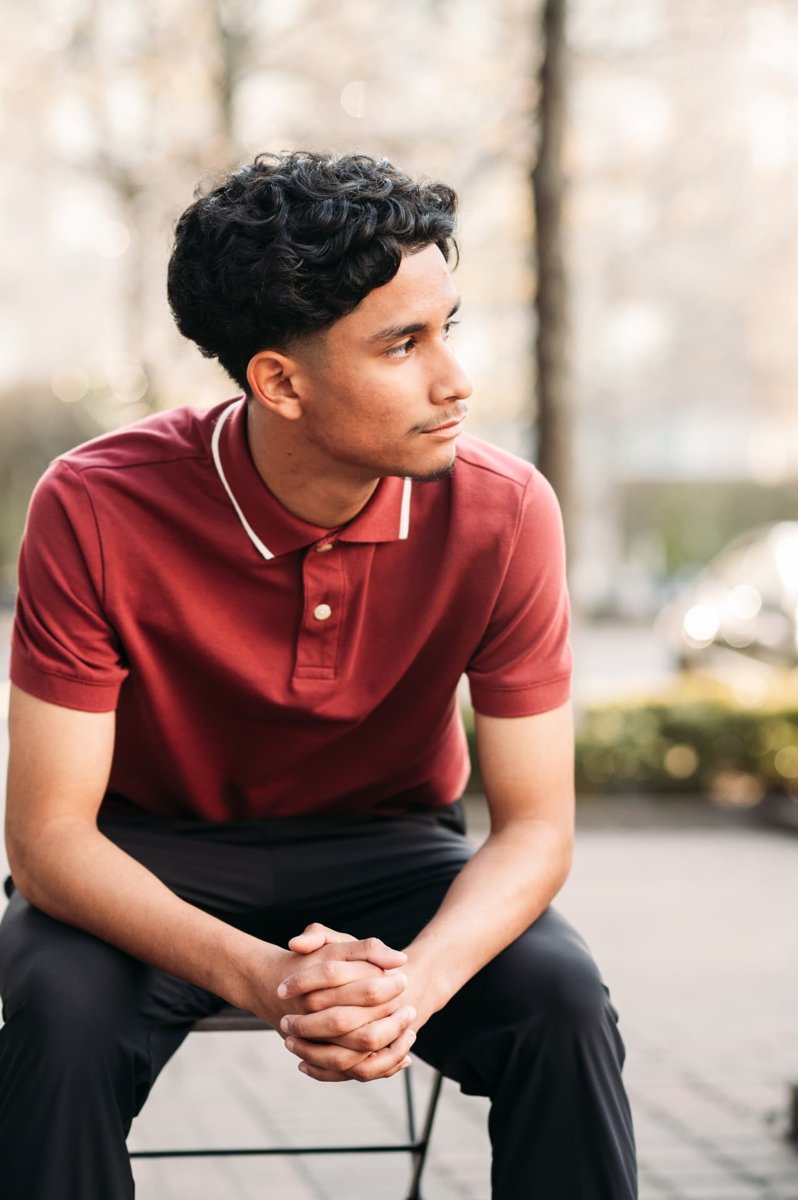 Senior guy in a red polo looking off camera in the city — seniors photography in the Kansas City area