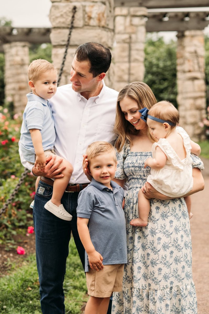 Family of five with three little ones in the rose garden pergola — family photography in the Kansas City area