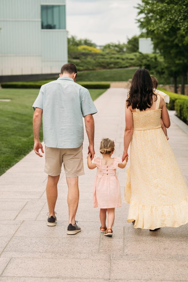 Family of four walking hand in hand at the Nelson-Atkins grounds — family photography in the Kansas City area