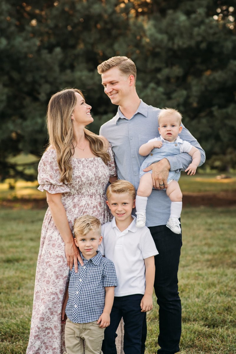 Parents laughing with their three boys during a sunset family session — family photography in the Kansas City area