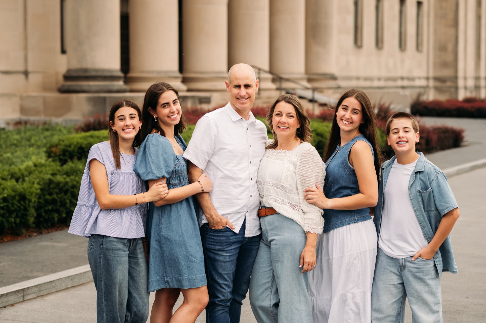 Family of six smiling in front of the stone columns at the Nelson-Atkins Museum of Art