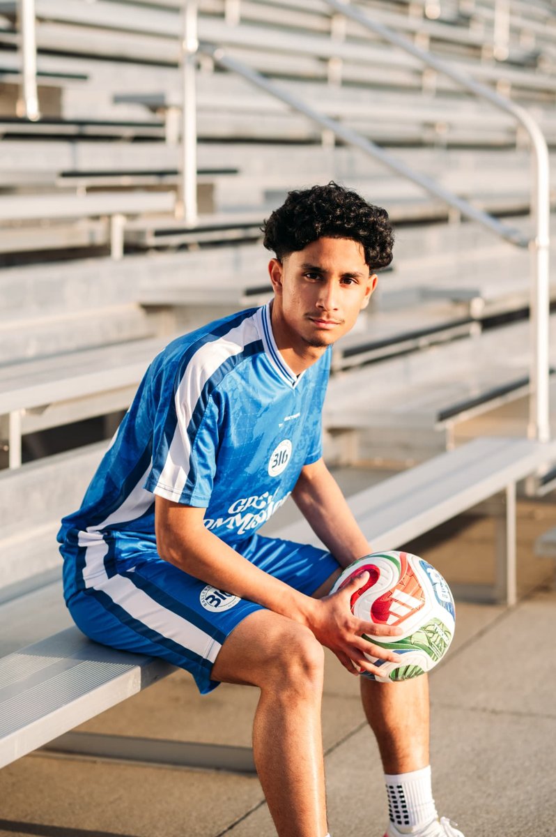 Senior soccer player seated on stadium bleachers with his ball