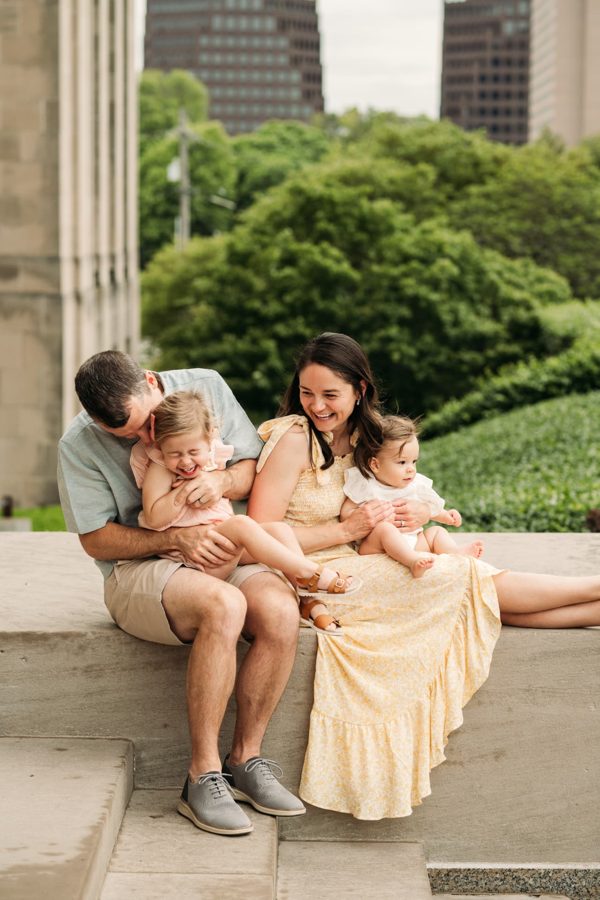 Family of four giggling together during a summer session in Kansas City — family photography in the Kansas City area