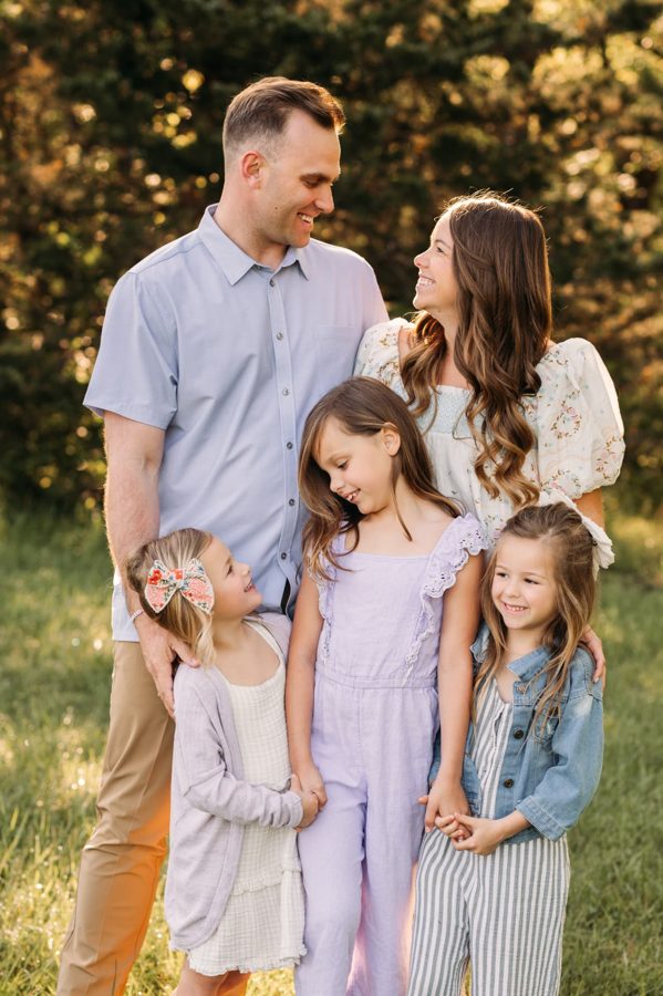 Parents smiling at each other surrounded by their three daughters — family photography in the Kansas City area