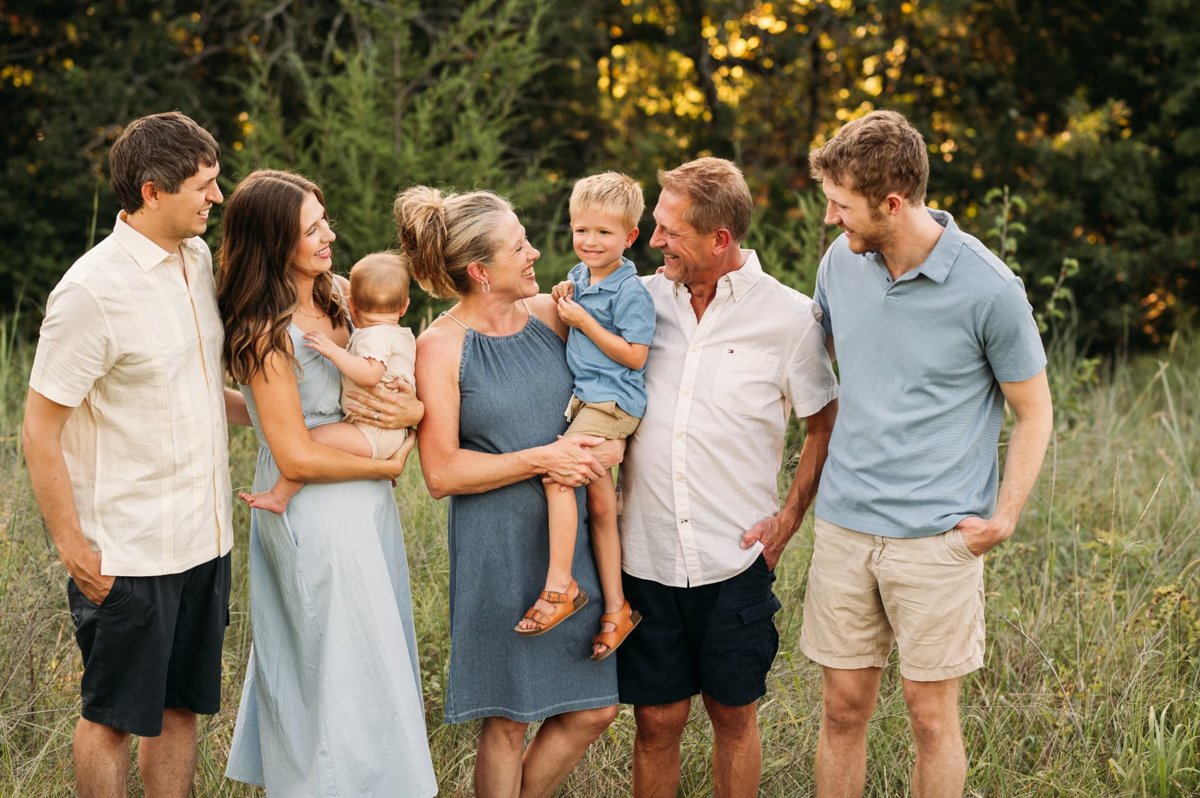 Three generations laughing together in golden evening light — family photography in the Kansas City area