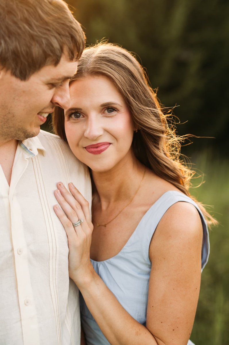 Wife resting her head on her husband's shoulder in backlit golden light — family photography in the Kansas City area