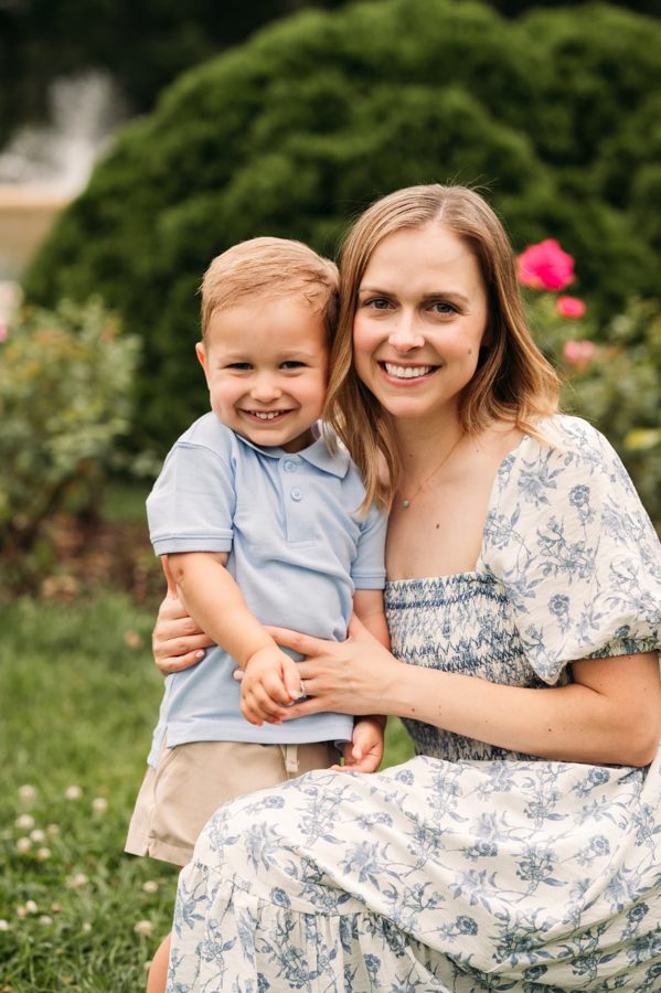 Mother and her toddler son smiling together among the roses — family photography in the Kansas City area
