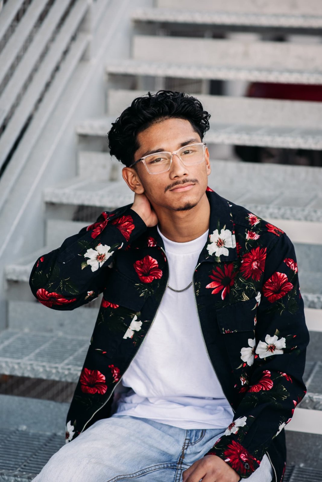 Senior guy in a floral jacket sitting on metal stairs in the Crossroads, Kansas City