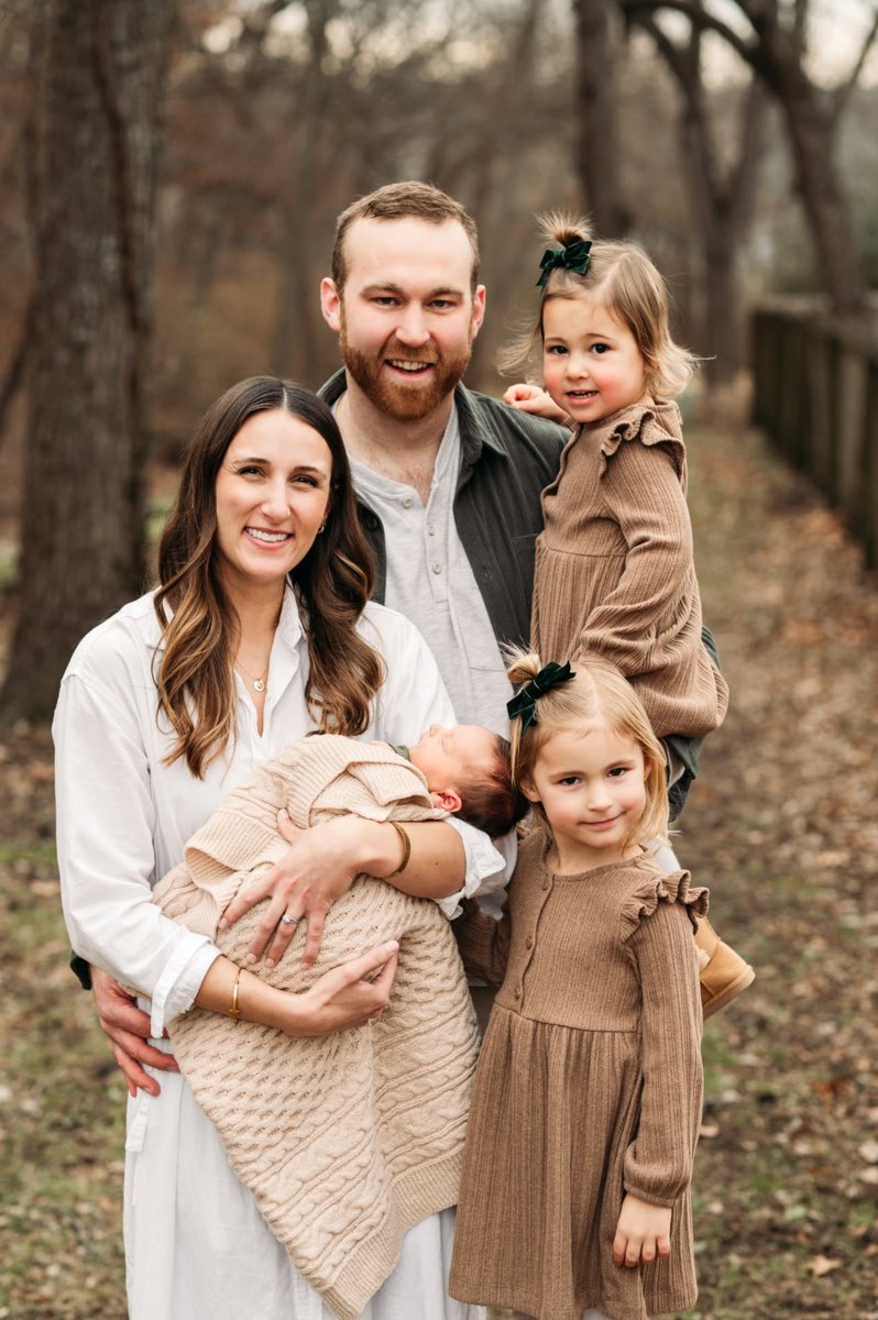Family of five outdoors in winter woods with their newborn baby — newborn photography in the Kansas City area
